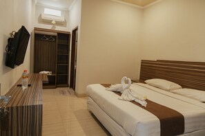 Habitación de hotel con cama, escritorio, espejo y armario.