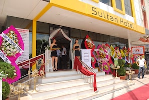 The entrance of Sultan Hotel with steps leading up to the entrance, decorated with flowers and a red drape. - Sultan Hotel (Mersin)