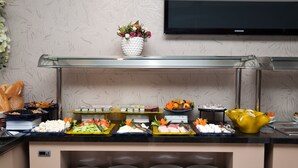 A buffet setup with various food items and a glass display case. - Sultan Hotel (Mersin)