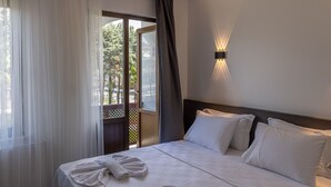 A hotel room with a bed, a window with curtains, and a wall-mounted light. - Olinda Hotel Agva (Sile)