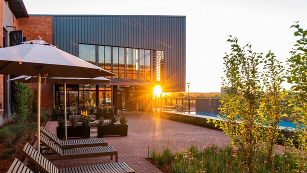A modern building with a pool and outdoor seating area. - Urban Hotel Kathu (Kathu)