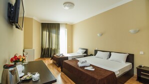 A hotel room with two beds, a desk with a coffee maker, a TV mounted on the wall, and a window with curtains. - Hotel Egrisi (Batumi)