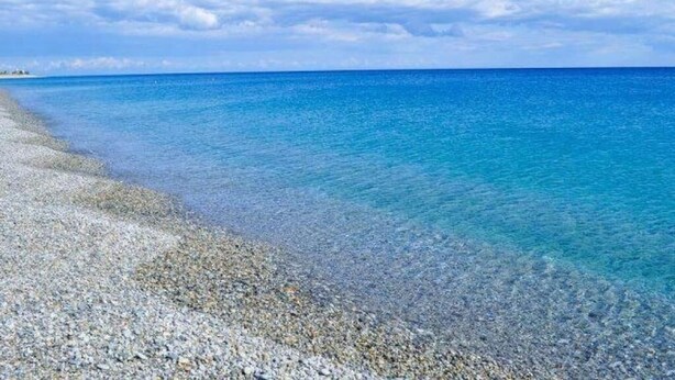 A clear beach with pebbles and calm blue water under a bright sky. - B&B Shalom (Condofuri)