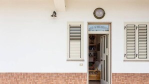 A building entrance with a sign reading "BED & BREAKFAST" and a bell above the door. - B&B Shalom (Condofuri)