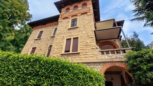 A stone building with a balcony and a small archway. - Ramé Suites (Bergamo)