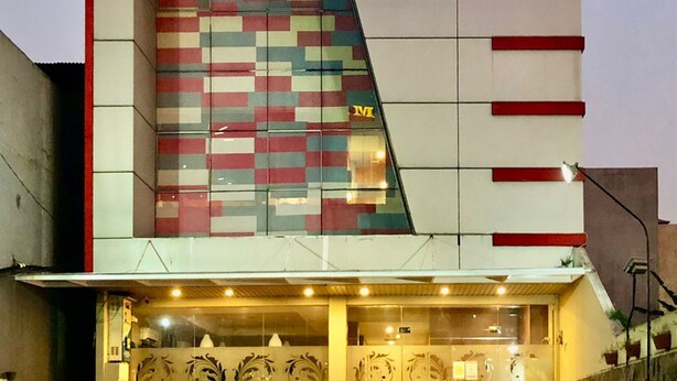 A hotel named Syariah with a modern design, featuring a checkered pattern on the facade and a prominent 'HOTEL QUDS EXPRESS' sign. - Quds Express Hotel (Jakarta)