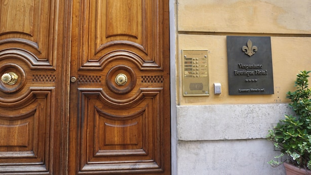 A wooden double door with a brass handle and a plaque reading "Vespasiano Boutique Hotel." - Hotel Vespasiano (Rome)