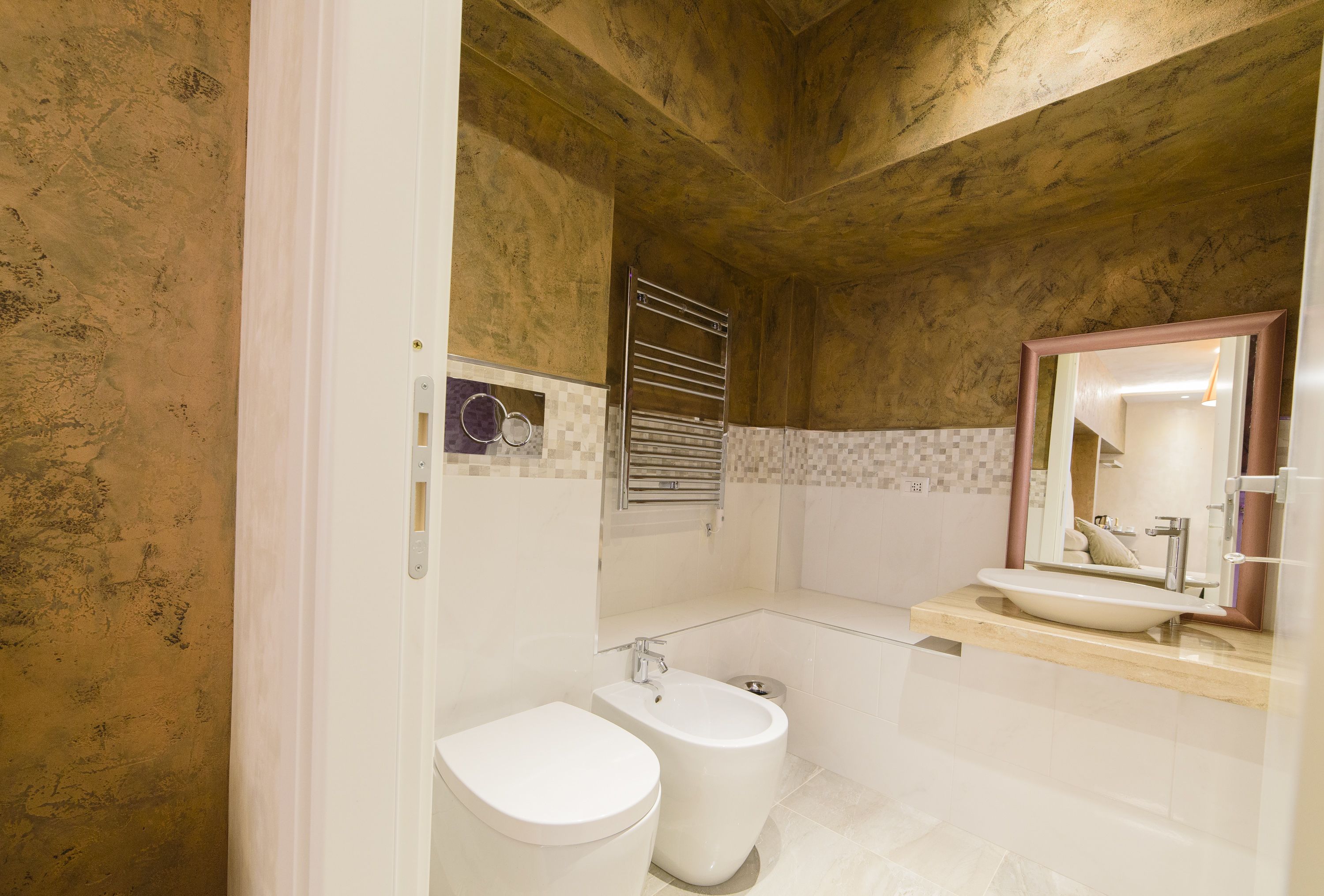 A bathroom with a white toilet, bidet, and sink.