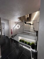 A modern staircase with metal railings and a polished black floor.