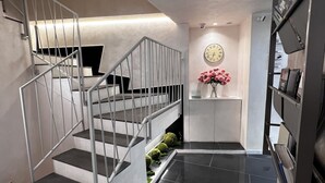 A modern staircase with metal railings and black steps leading to a landing. - Hotel Vespasiano (Rome)