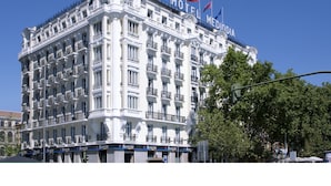 A historic hotel with multiple balconies, a classic architectural style, and flags on the roof. - Hotel Mediodia (Madrid)