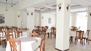 A spacious dining area with multiple tables and chairs, high ceilings with decorative lighting, and a clean, well-maintained interior. - Villa Bellevue -Golden Sands Nature Park (Golden Sands)