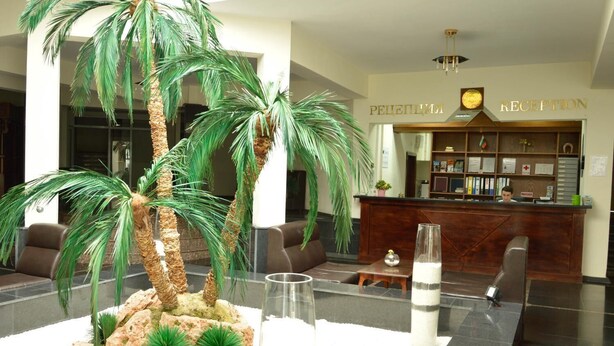 A reception area with a reception desk, a receptionist, and a reception sign.