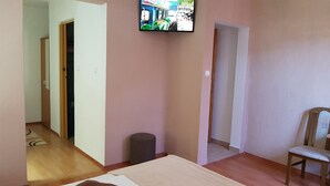A room with a television mounted on the wall, a wooden chair, and a small rug on the floor. - St. George B&B (Plitvicka Jezera)