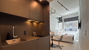 Una cocina moderna con estufa integrada, un lavabo y un pequeño comedor con mesa y sillas.
