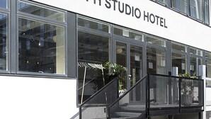 El exterior del CPH Studio Hotel, con amplias ventanas, una escalera y plantas en macetas.