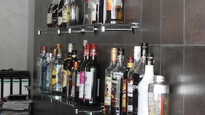 A bar area with shelves stocked with various liquor bottles. - Venus Premier Hotel (Arusha)