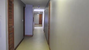 A hallway with wooden doors and a tiled floor. - Venus Premier Hotel (Arusha)