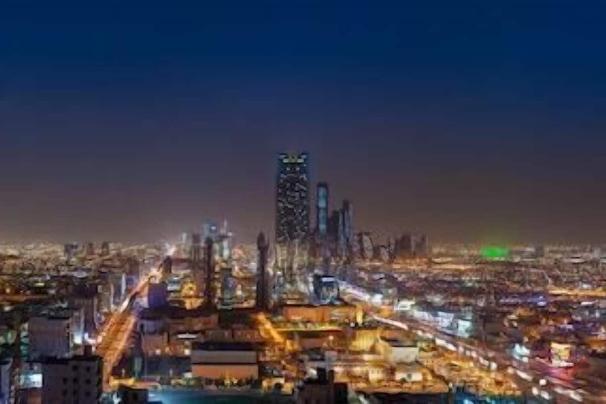 A nighttime cityscape with illuminated buildings and a prominent skyscraper.