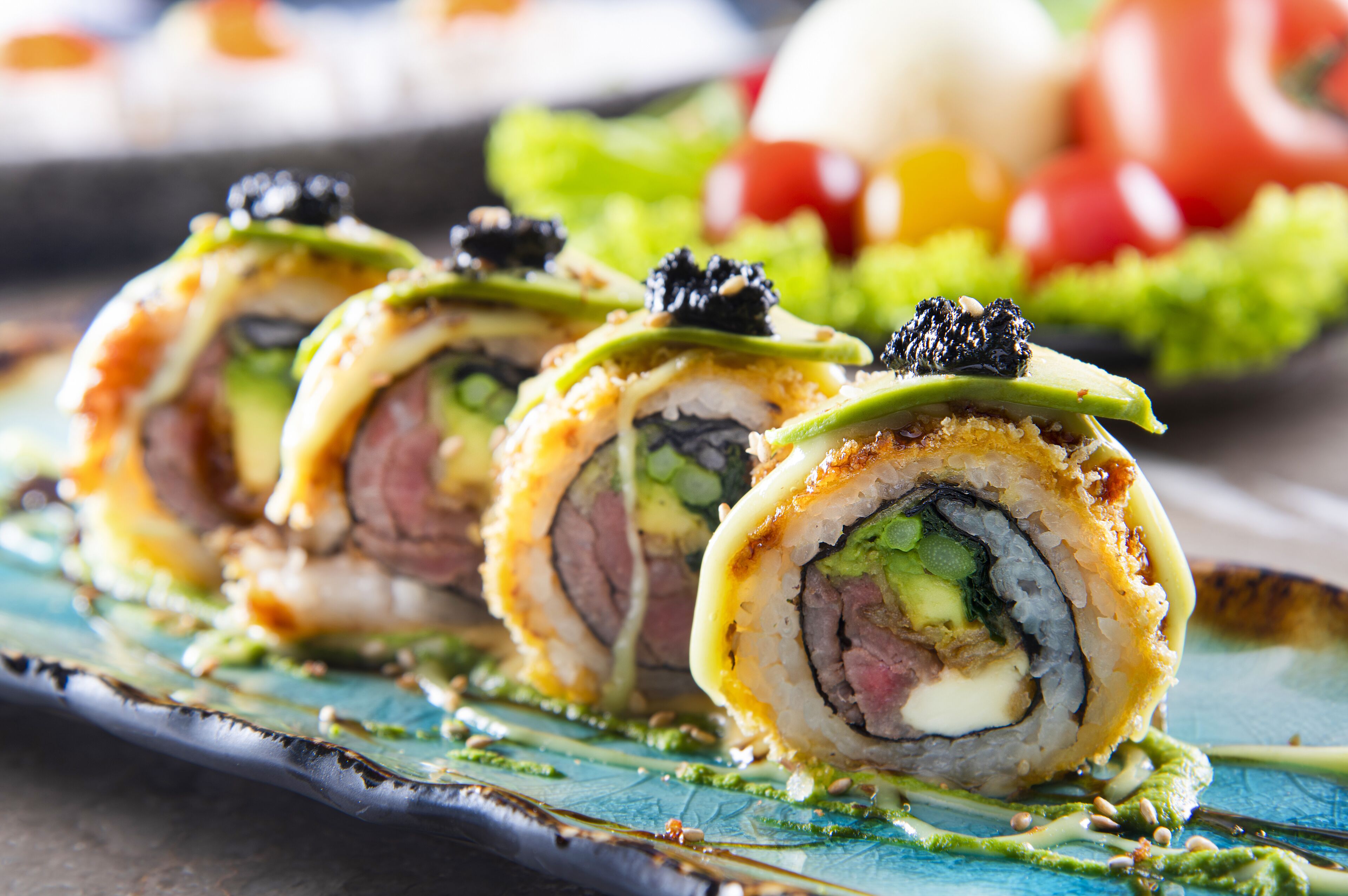 A sushi dish with various ingredients and a green sauce.