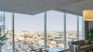 Ein großzügiges Wohnzimmer mit raumhohen Fenstern und Blick auf die Stadt.