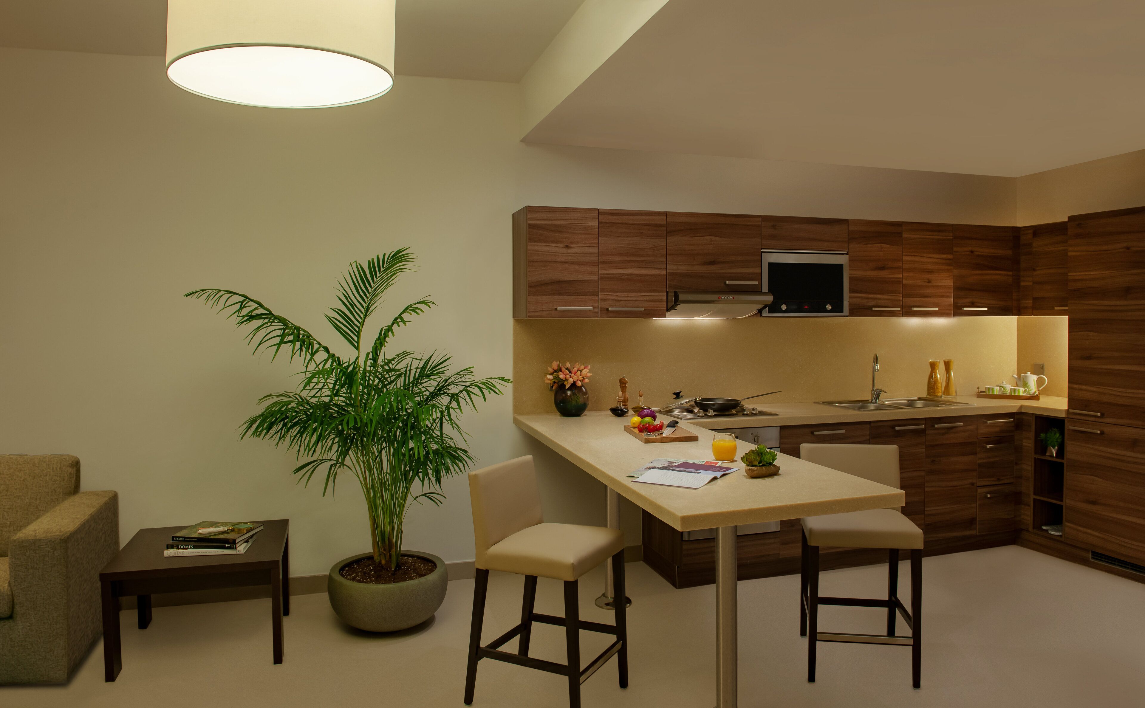 Une cuisine moderne avec des meubles en bois, un four encastré et un coin repas comprenant une table et des chaises.