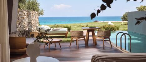Habitación con vista al mar, piscina y mobiliario de exterior.