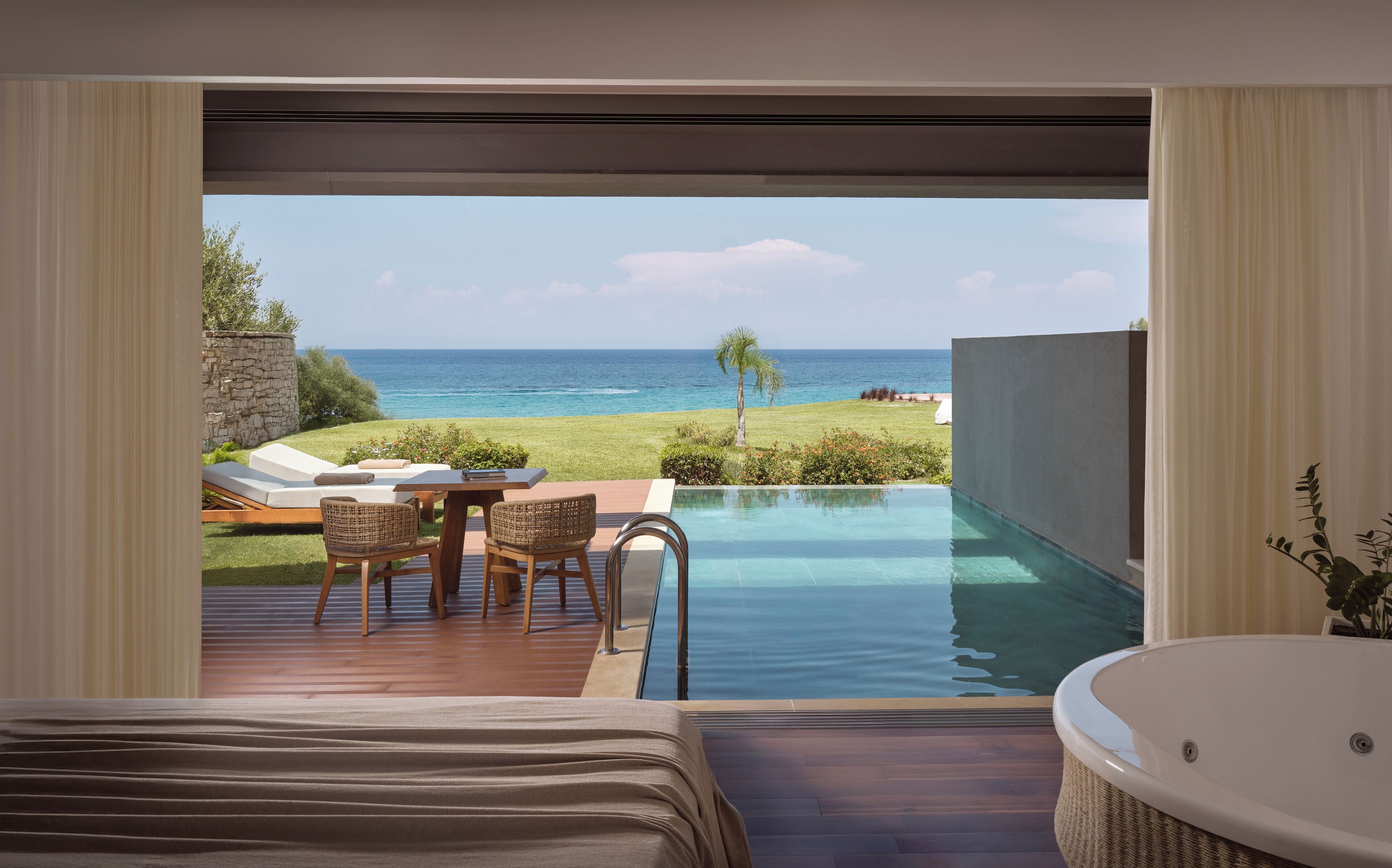 Una camera da letto con vista sulla piscina e sull'oceano.
