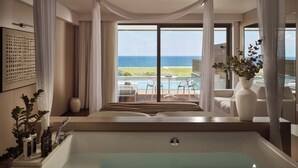 A modern bathroom with a large bathtub, a view of the sea, and a pool area visible through large windows. - Lesante Blu - The Leading Hotels of the World, Adults Only (Zakynthos)