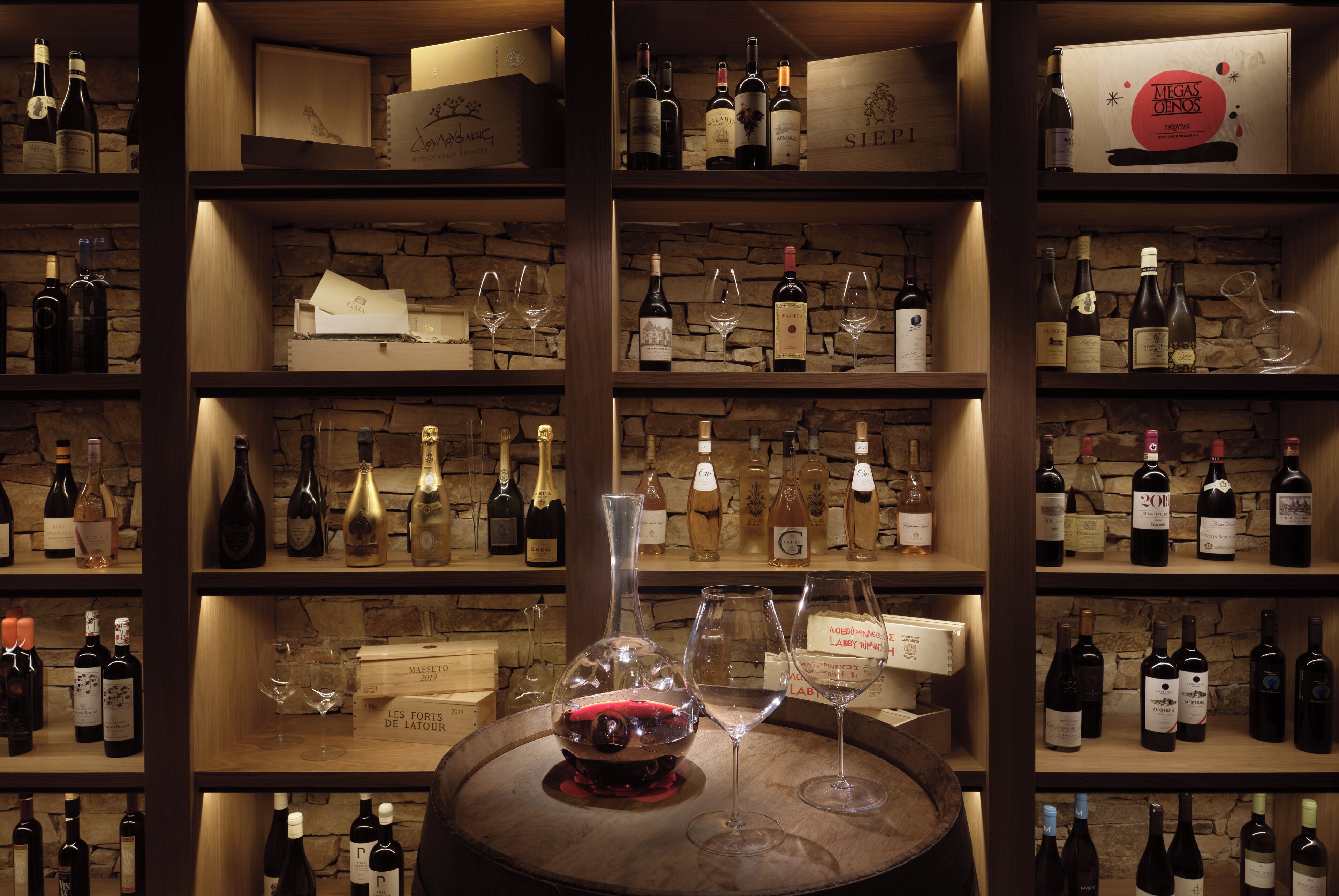 Una cantina vinicola con scaffali pieni di bottiglie e bicchieri di vino.