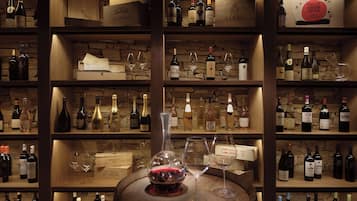Una cantina vinicola con scaffali pieni di bottiglie e bicchieri di vino.