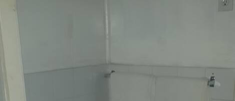 A small bathroom with a toilet, a sink, and a shower area.