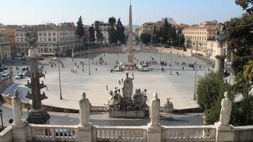 A spacious square with a central obelisk, surrounded by classical statues and fountains.