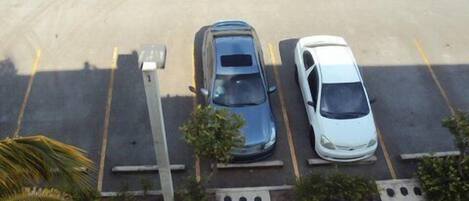 Un estacionamiento con tres coches aparcados en plazas asignadas.
