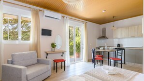 Une chambre d’hôtel moderne équipée d’un canapé, de deux lits, d’un coin repas et d’une cuisine.