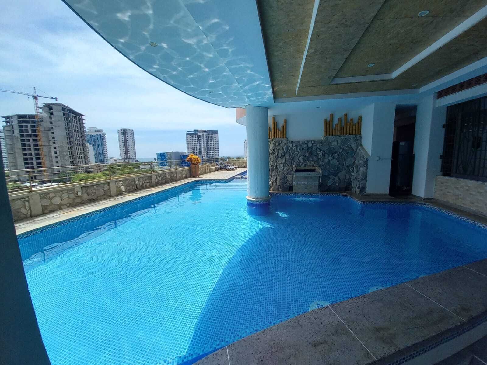 Μια πισίνα στην ταράτσα με θέα στα γύρω ψηλά κτίρια.