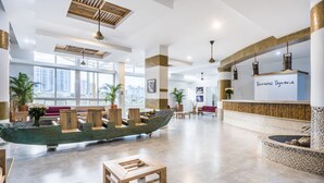 A spacious lobby with a large wooden boat centerpiece, a reception desk, and modern lighting fixtures.