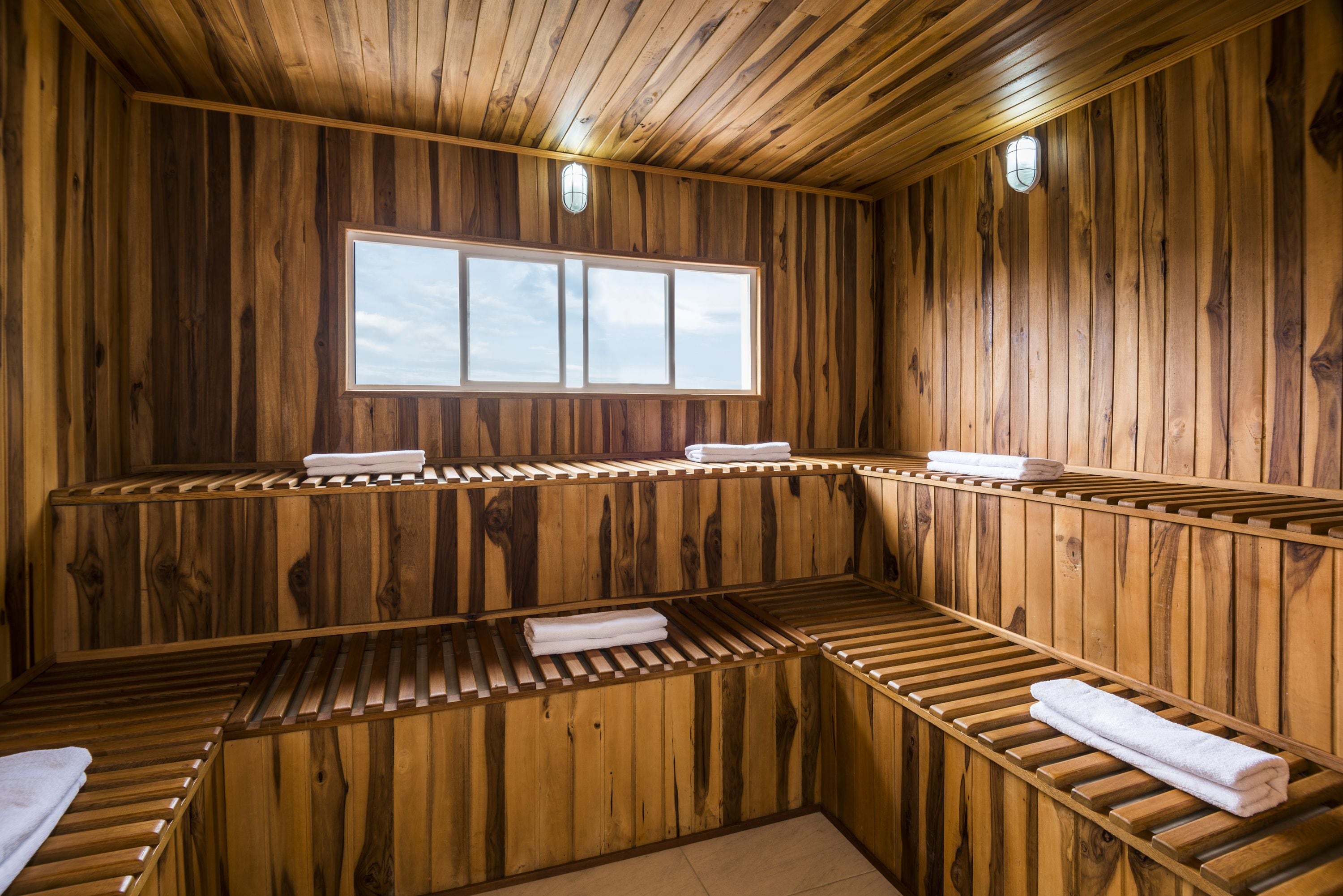Una spa con stanza in legno, panche integrate e una finestra.