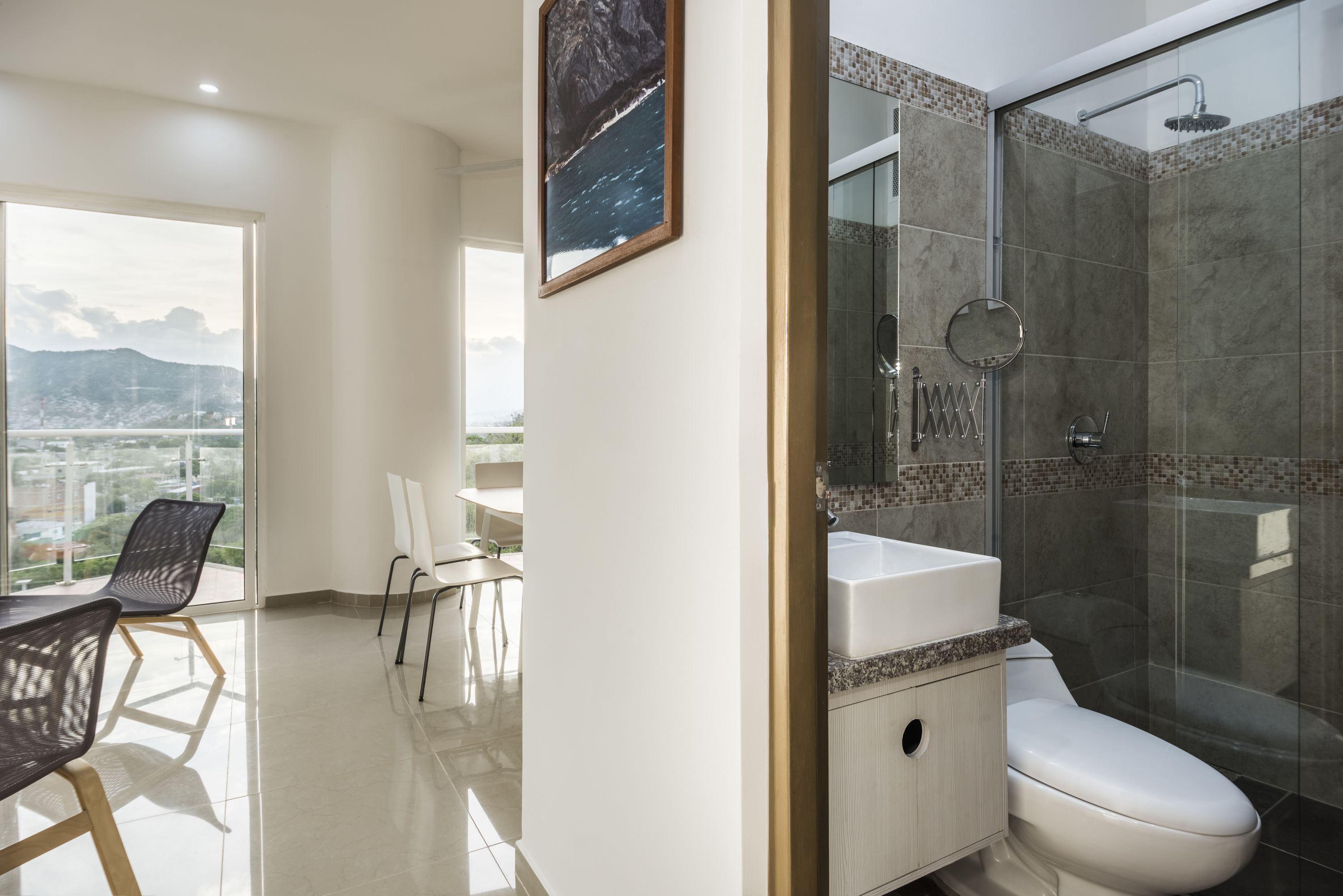 A modern bathroom with a glass shower enclosure, a white sink, and a toilet.