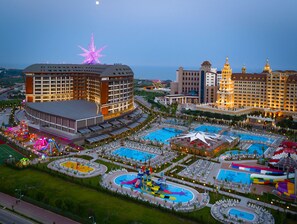 A resort with multiple swimming pools, a large illuminated star, and a variety of amenities including a water park and a large hotel building. - Royal Seginus - All Inclusive (Antalya)