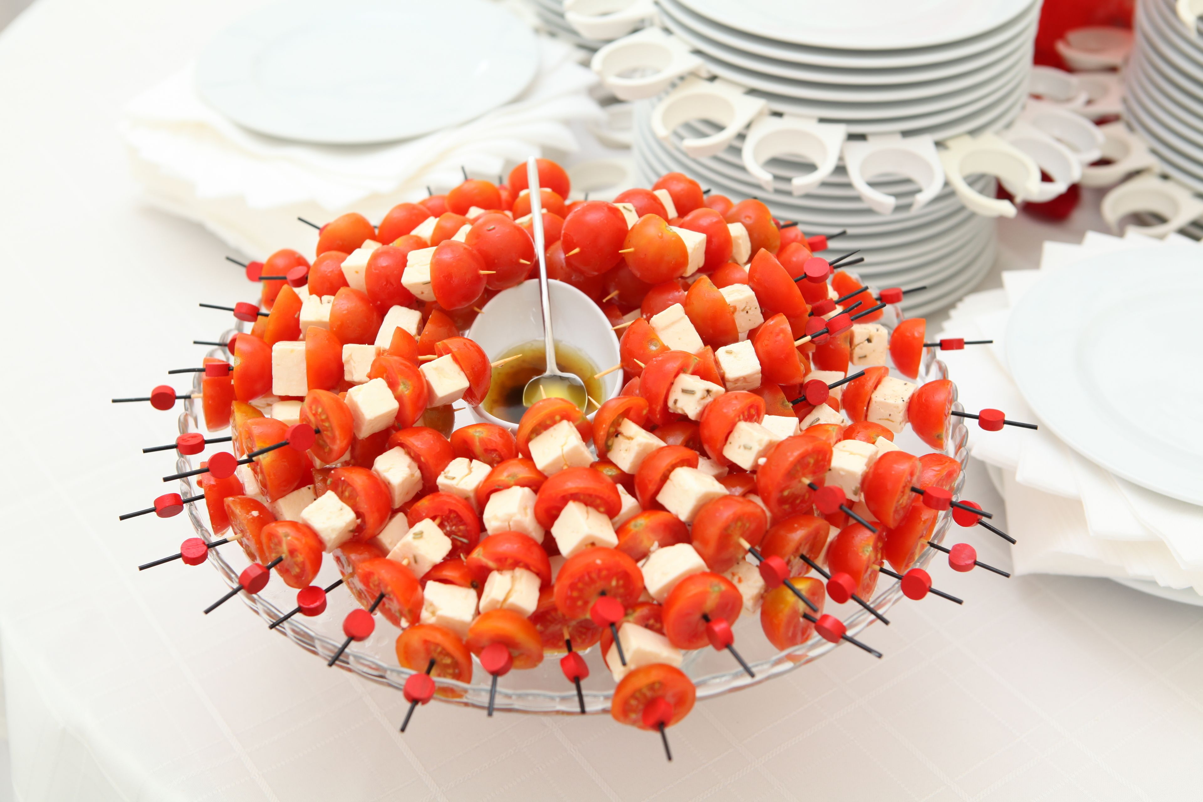 A platter of skewered tomatoes and cheese.