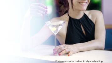 A person sitting at a table with a martini glass.