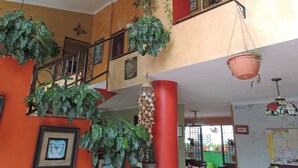 A multi-level interior with balconies, potted plants, and a staircase. - Panama Canal Inn (Panama City)