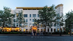 A hotel with a classic architectural style, featuring a central entrance with a decorative archway and a sign above it. - Hotel Hive (Washington)