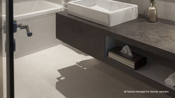 A modern bathroom with a large mirror, a bathtub, a sink, and a towel rack.