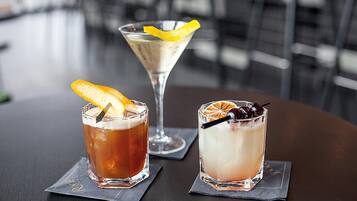 Trois cocktails sont posés sur une table, accompagnés de serviettes.