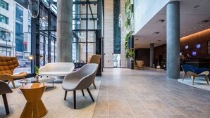 A spacious lobby with modern furniture, large windows, and a reception area. - Radisson Blu Hotel, Mannheim (Mannheim)