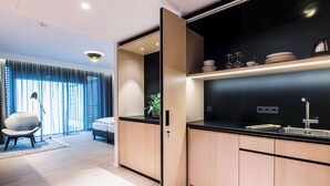 A modern kitchen with wooden cabinets, a black countertop, and a built-in sink. - Radisson Blu Hotel, Mannheim (Mannheim)