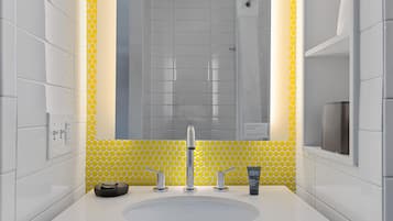 A bathroom with a white sink, a mirror, and yellow patterned tiles.