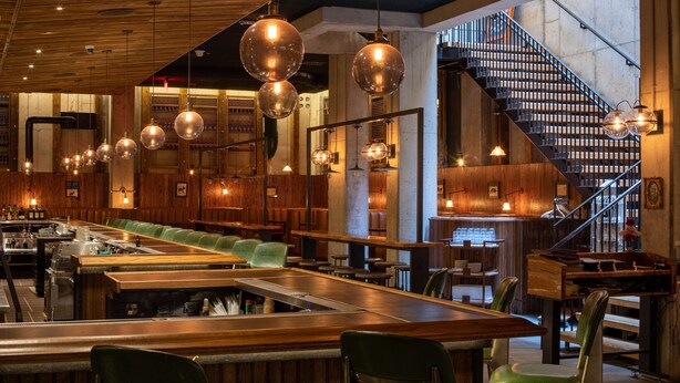 A restaurant with a bar area, wooden ceiling, hanging spherical light fixtures, and a staircase. - Motto by Hilton Washington DC Downtown (Washington)